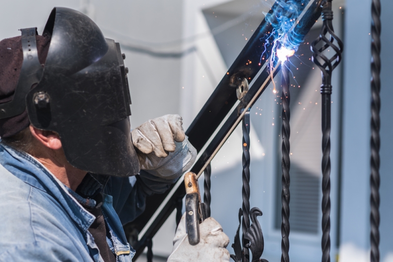 Ferronnier travaillant une structure en fer forgé