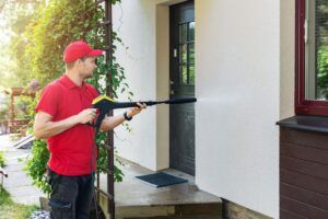 Professionnel qui nettoie la façade d'une maison