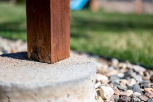 Poteau en bois sur une dalle en béton