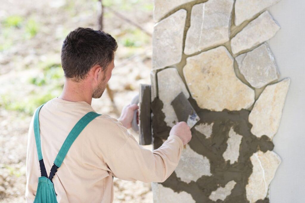 Maçon qui construit un mur